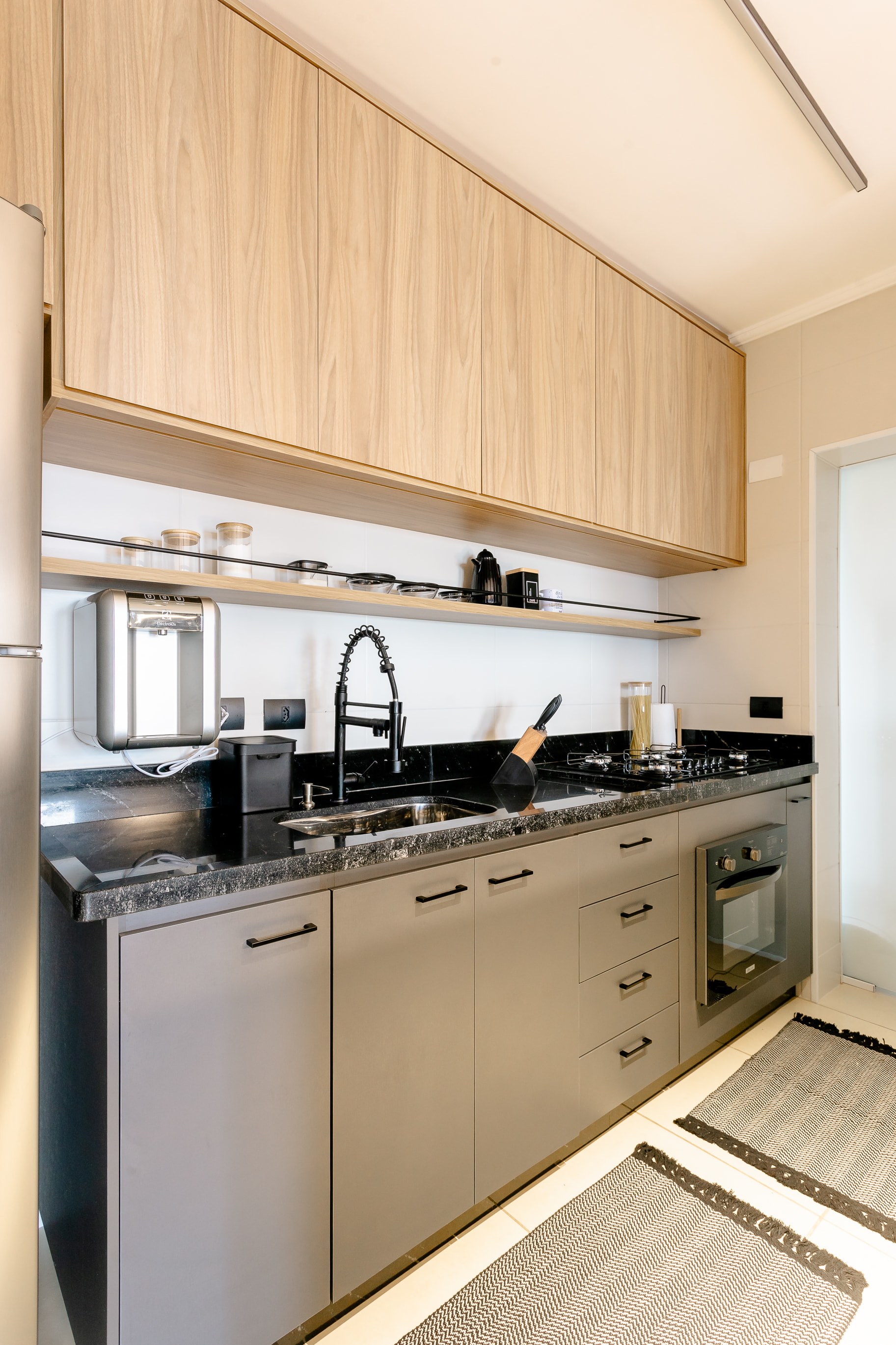 Painel de TV em cimento queimado com nichos de madeira no projeto de interiores moderno