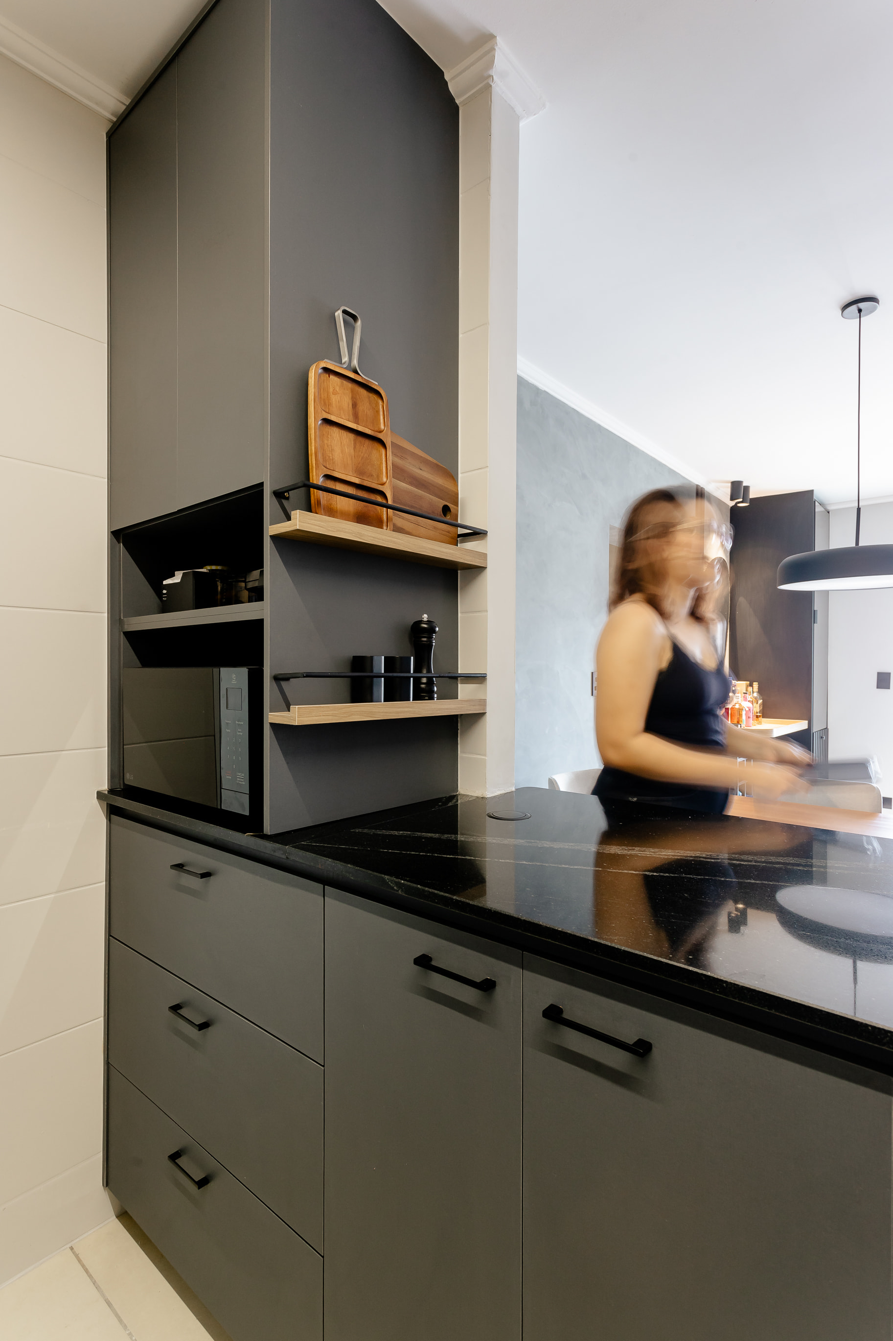 Banheiro social moderno com revestimentos neutros e box de vidro escuro